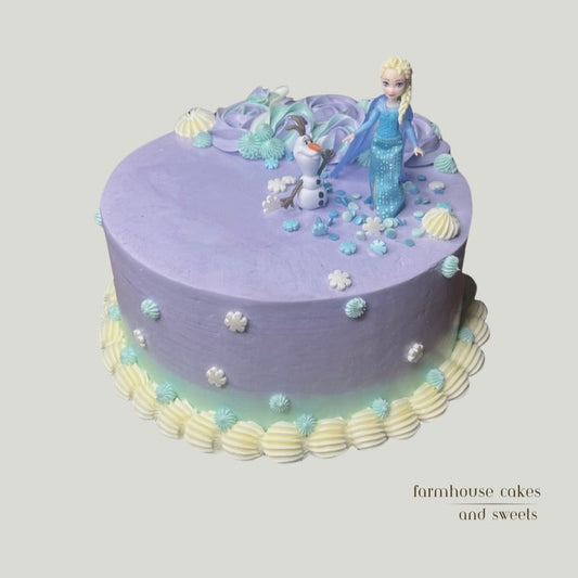 Icy princess themed cake with lavender and sky blue ombre color buttercream, snowflake decorations, and white piping details.