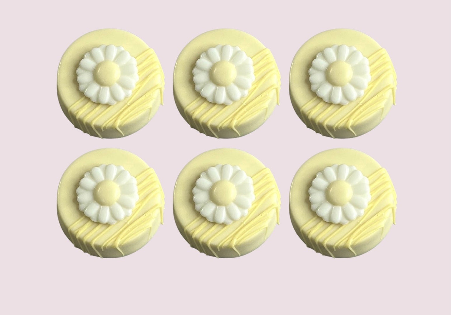 Set of six pastel yellow chocolate-covered Oreos with daisy toppers and decorative drizzle perfect for spring events and dessert platters. 
